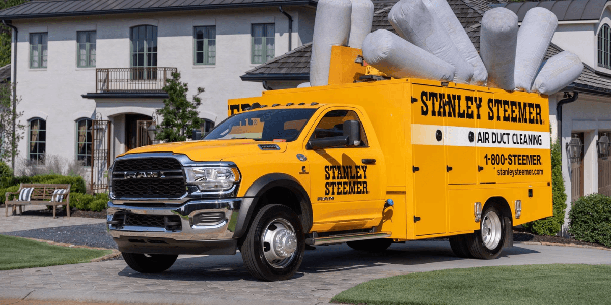 Yellow Stanley Steemer truck for air duct cleaning parked in a residential area