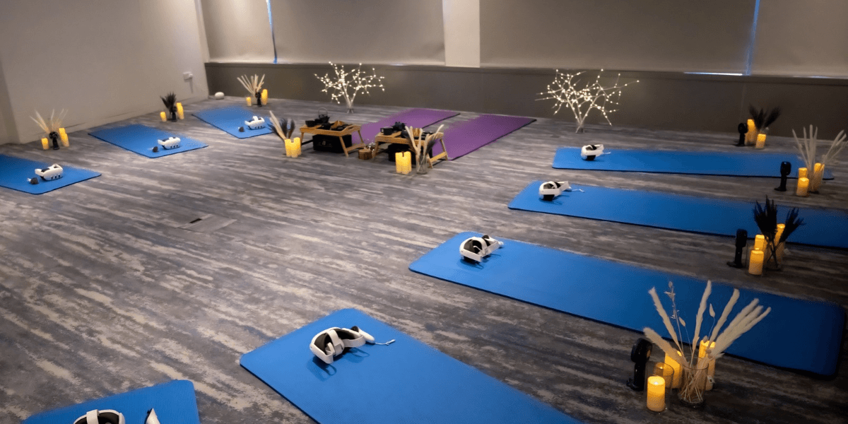 A serene yoga space with blue mats, virtual reality headsets, and soft lighting.