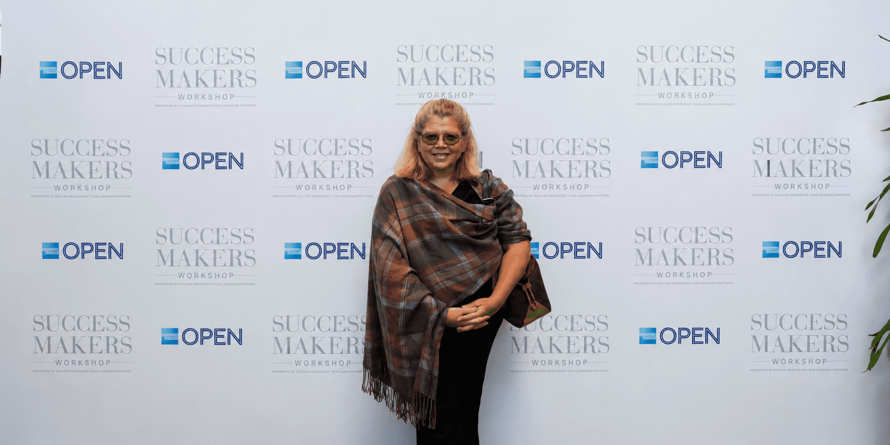 Janet Walker standing in front of a Success Makers Workshop and OPEN event backdrop.