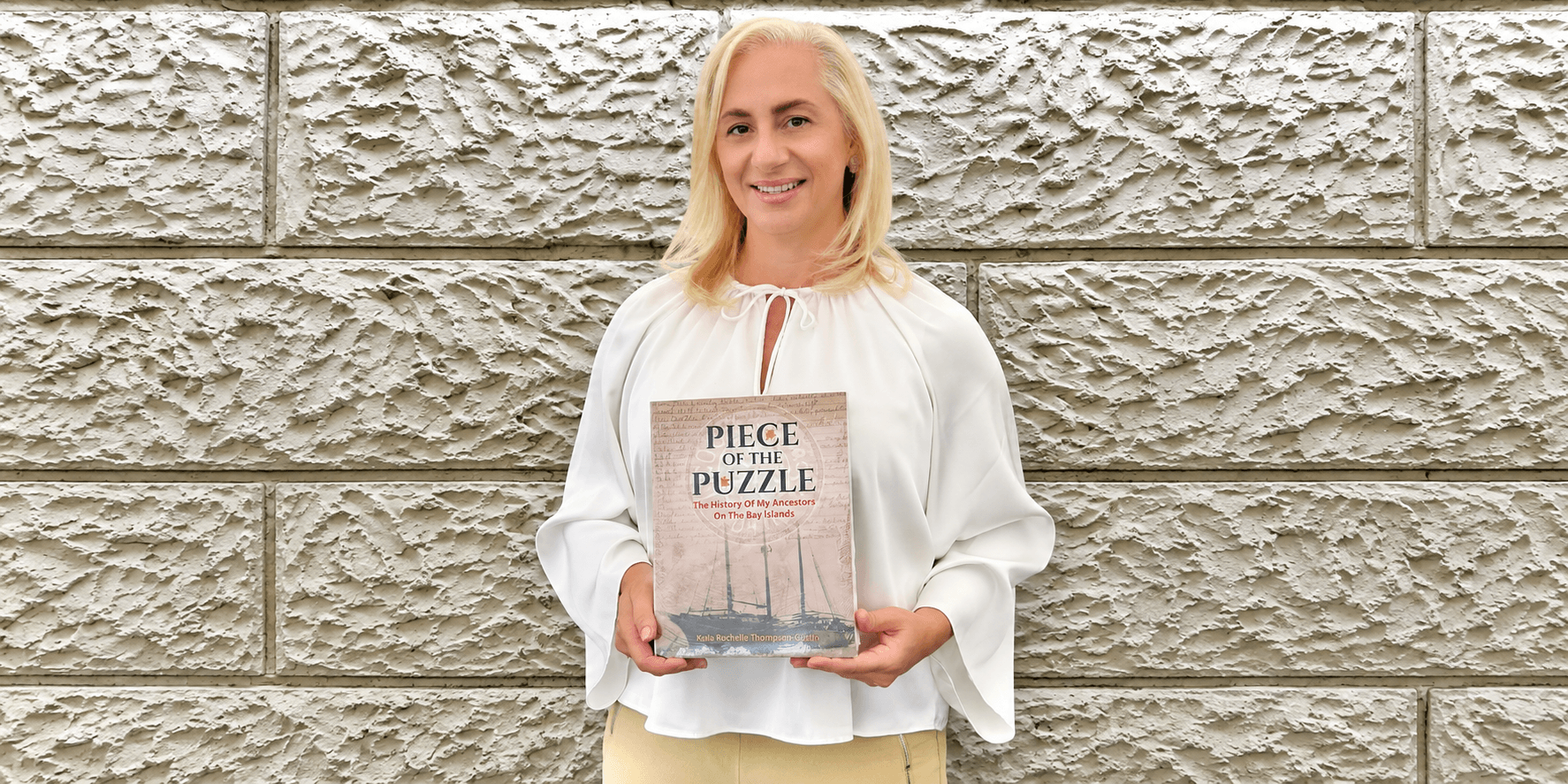 Person holding a book titled "Piece of the Puzzle" with a textured wall background