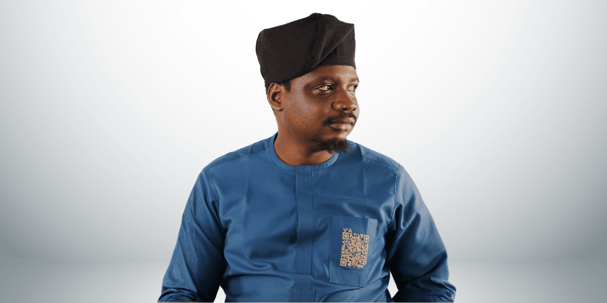 Man wearing a traditional outfit with a black cap, looking to the side