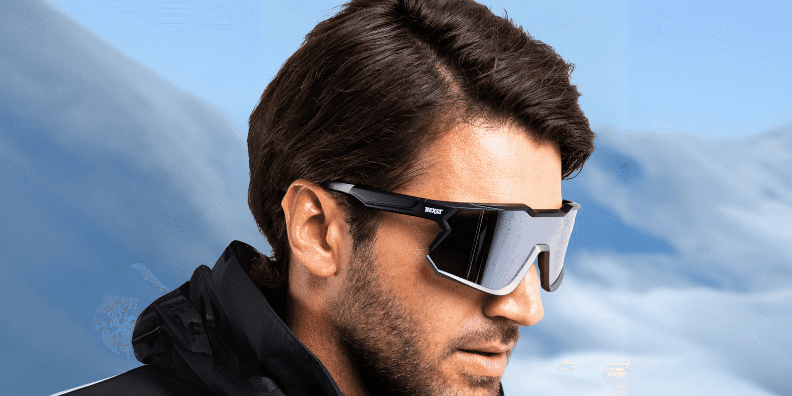 "Profile shot of a man wearing high-performance sunglasses with a mountain backdrop, highlighting the stylish design and functional eyewear for outdoor activities."