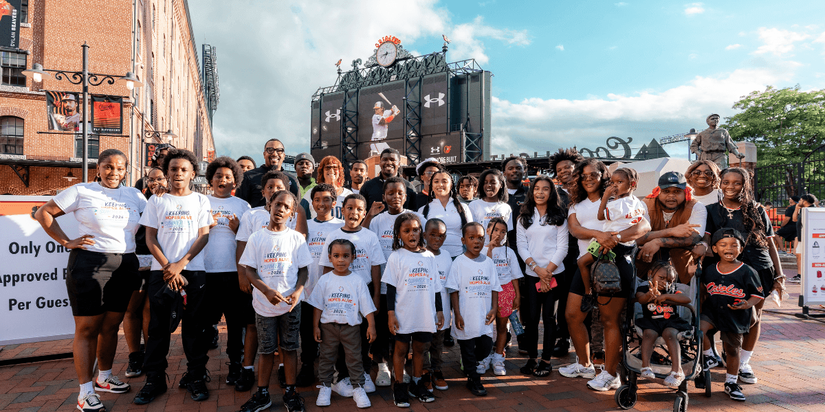 Keeping Hopes Alive youth, families, and mentors gather for a group photo outside Camden Yards.