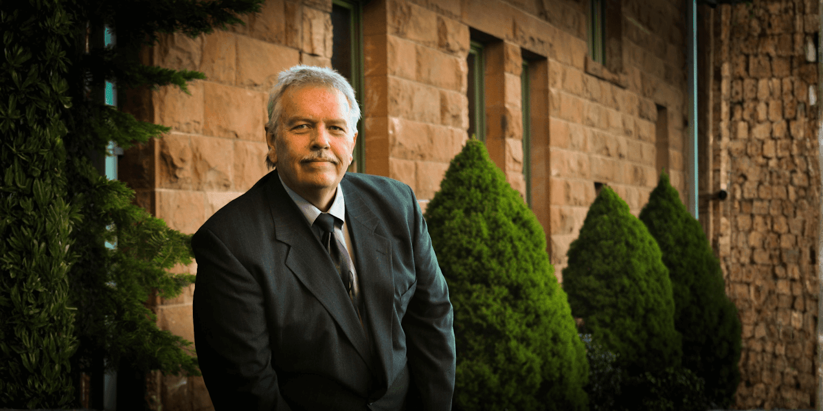 Eric Ridley, estate planning attorney, standing confidently outside his office in a professional suit, representing his firm’s dedication to family protection.