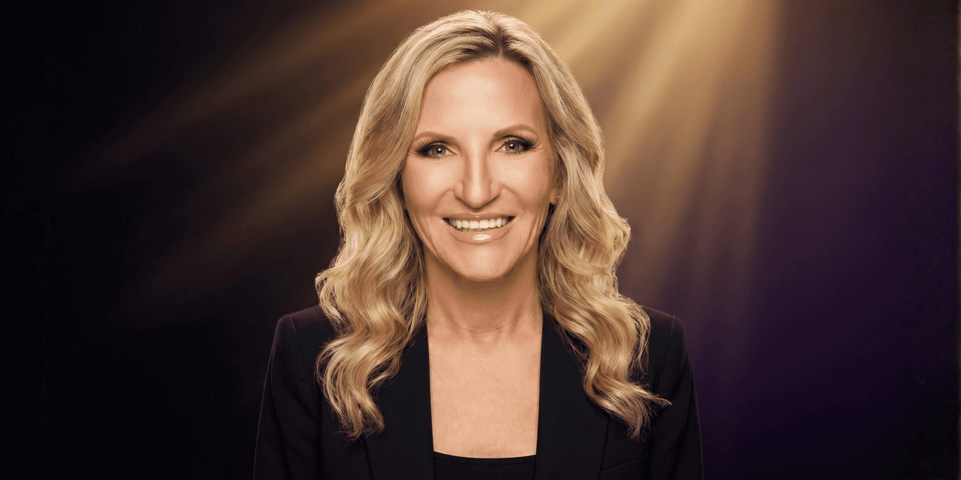 Portrait of Jessie Tylre Williams smiling under spotlight, symbolizing resilience, recovery, and personal transformation.