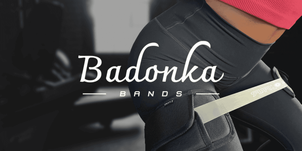 Close-up of person wearing Badonka Bands resistance sleeves during workout, showcasing RR Health + Fitness branding and design.