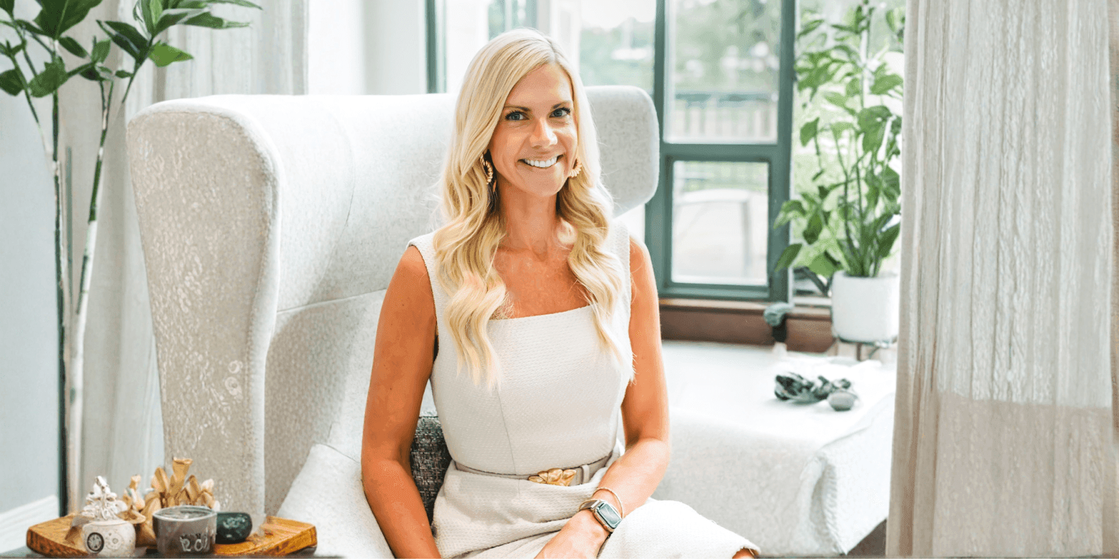 Sara Lewis Hartley smiles while seated in a calming, light-filled space, reflecting her compassionate parenting philosophy.