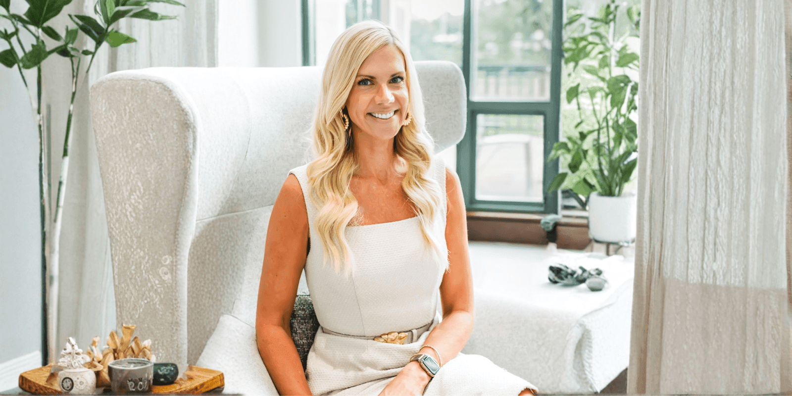 Sara Lewis Hartley smiles while seated in a calming, light-filled space, reflecting her compassionate parenting philosophy.