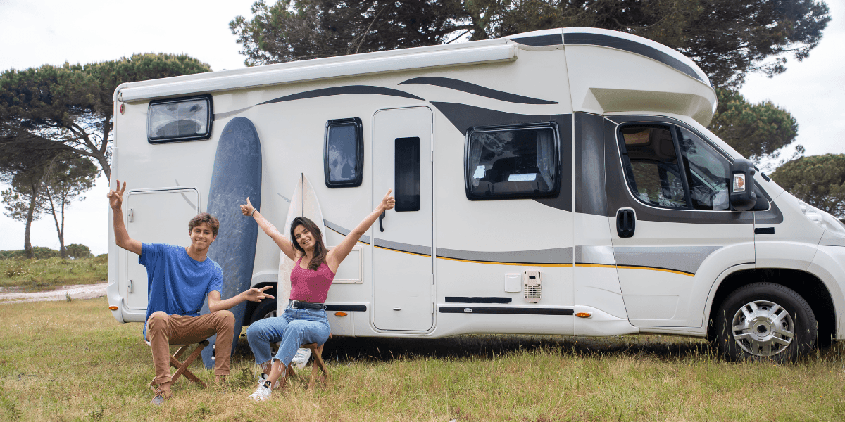 Two young adults smiling outside an RV, symbolizing freedom and remote work embraced by Millennials and Gen Z.
