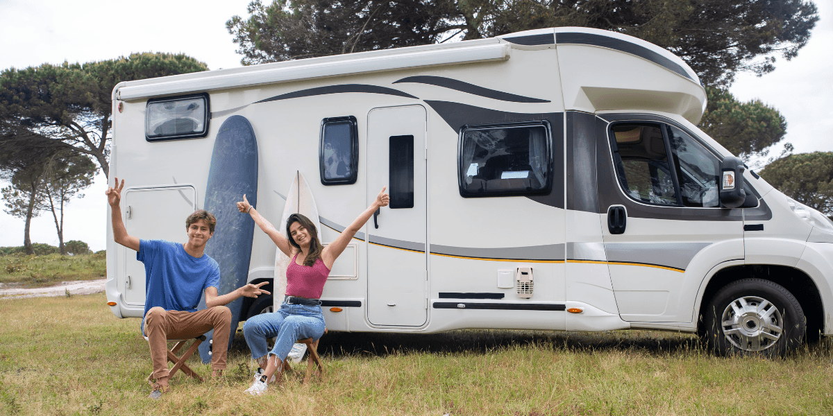 Two young adults smiling outside an RV, symbolizing freedom and remote work embraced by Millennials and Gen Z.