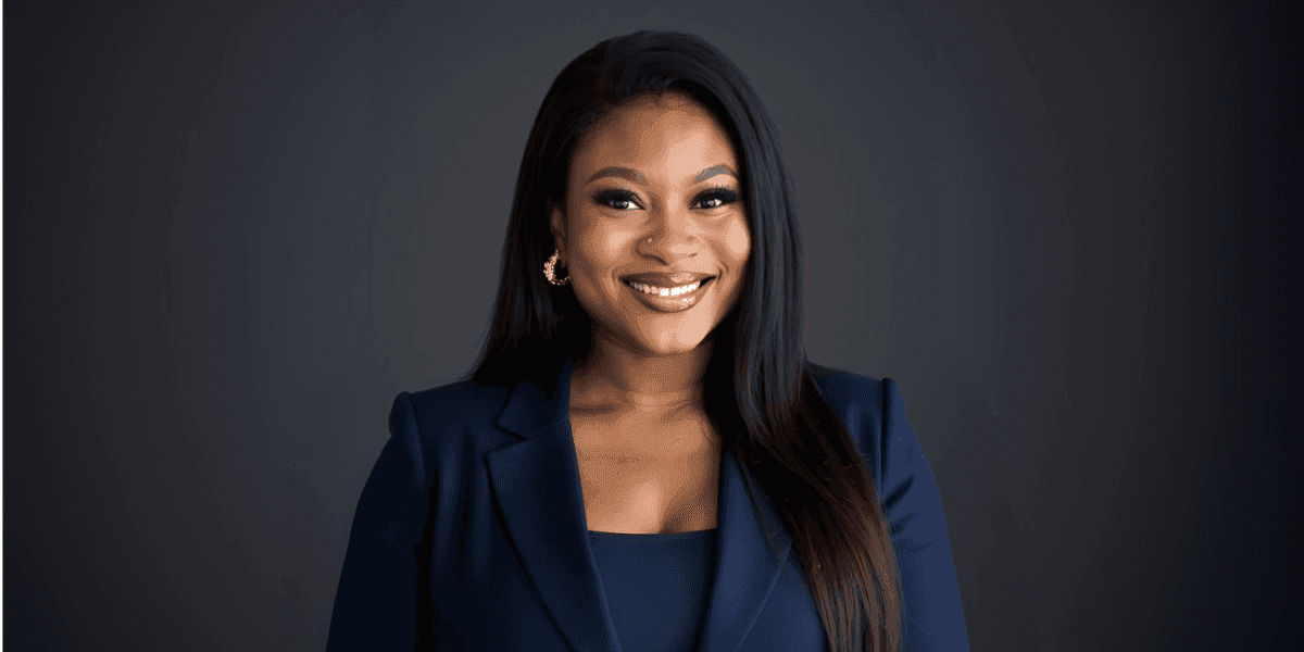 Portrait of Bukola Omotere, founder of Digital Wealth Creators Inc, smiling confidently in a navy suit with a professional backdrop