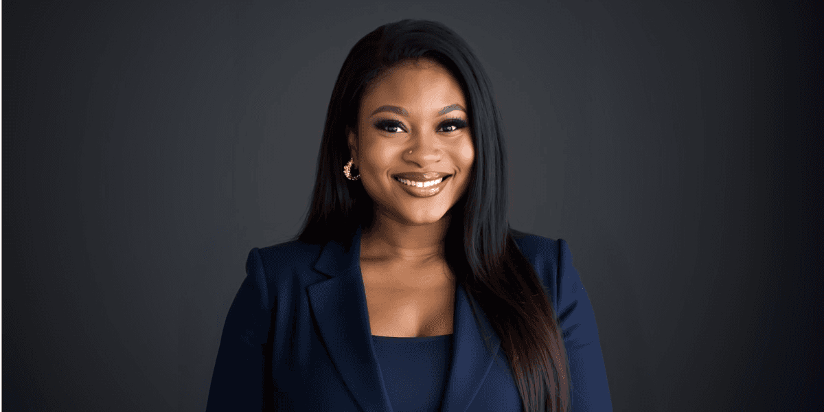 Portrait of Bukola Omotere, founder of Digital Wealth Creators Inc, smiling confidently in a navy suit with a professional backdrop