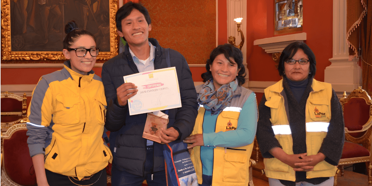 Daniela Jines stands with award recipients and community leaders during a certificate presentation ceremony.