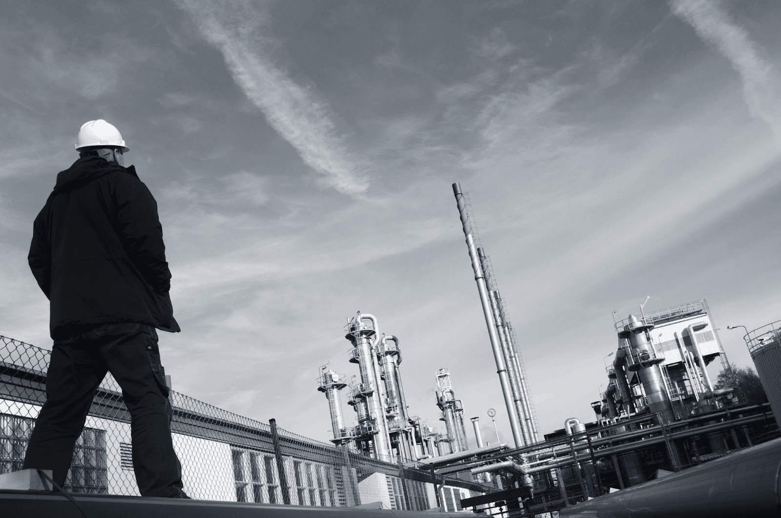 A worker inspects industrial pipelines at a refinery, embodying real-world experience emphasized by Velocity Training's practical exam prep.