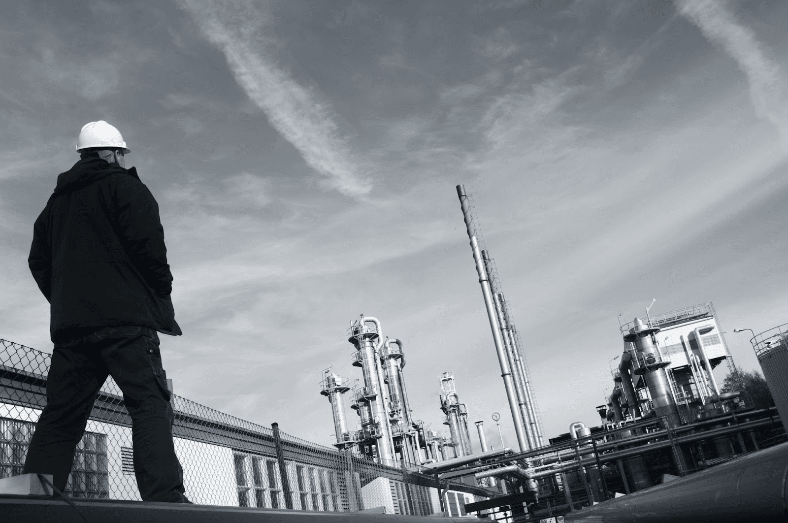 A worker inspects industrial pipelines at a refinery, embodying real-world experience emphasized by Velocity Training's practical exam prep.