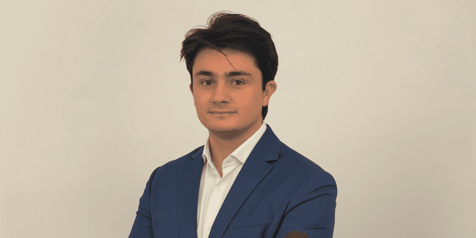 Marcos Agustín, in a blue suit and white shirt, embodies the vision of OpenMacro for accessible global macro investing.