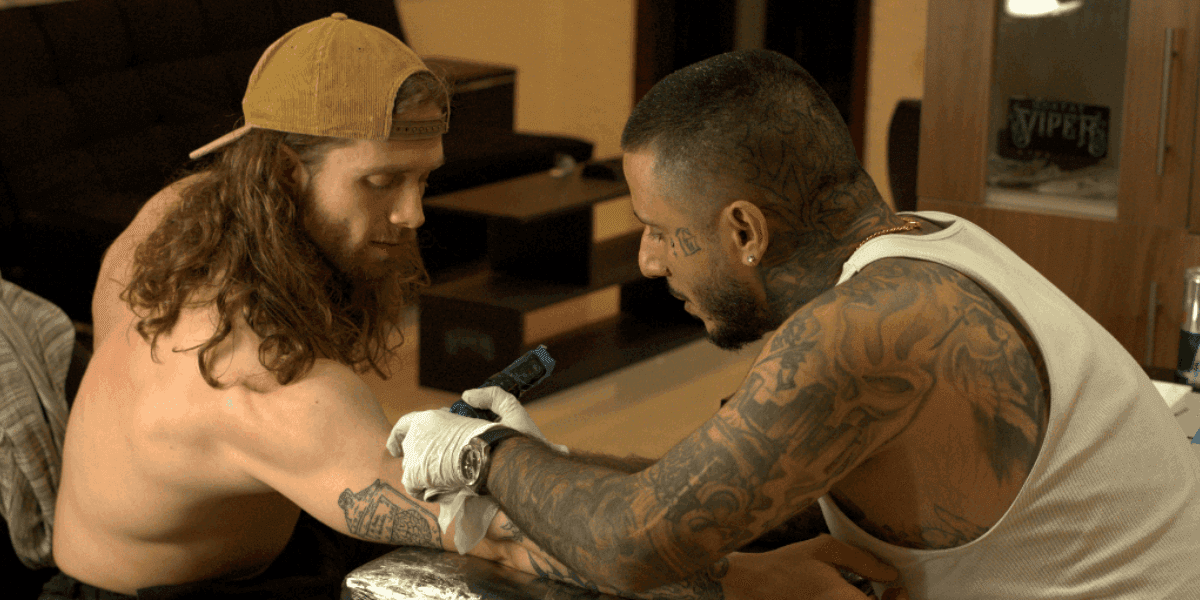 Tattoo artist working on a client's arm at Riders Studios, showcasing a personalized tattoo experience.