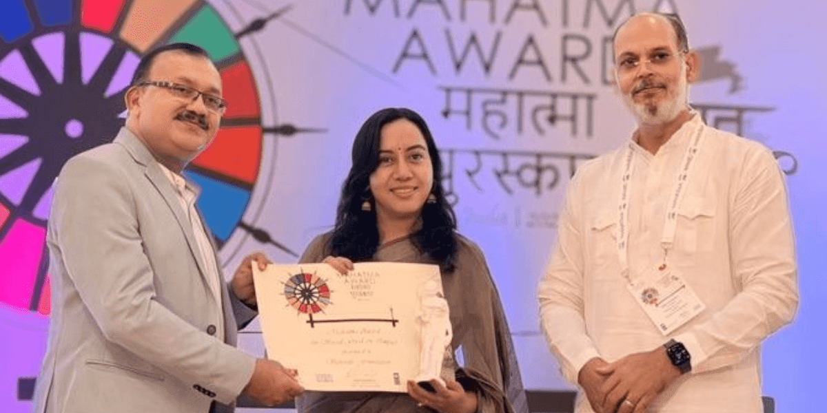 Three individuals at Mahatma Awards ceremony; Dr. Geeta Bora of Spherule Foundation receives Best Social Impact Organization 2025 recognition.