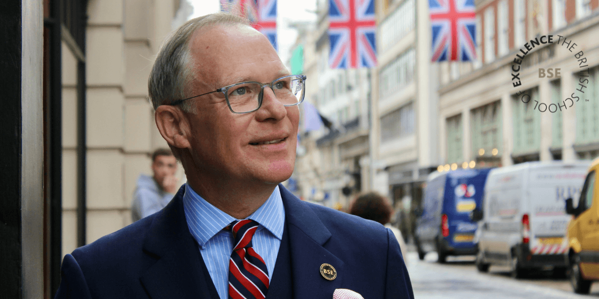 A man in a suit stands confidently on a London street, representing The British School of Excellence™️'s leadership programs.