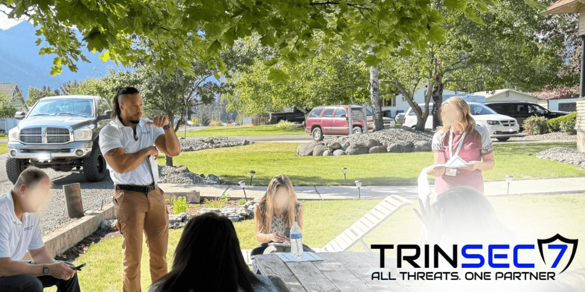 Outdoor meeting with participants listening to a speaker and taking notes in a scenic setting
