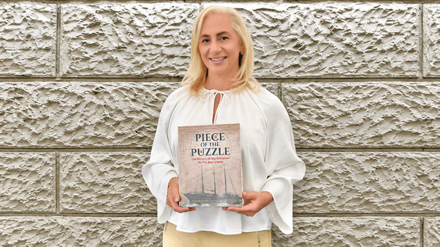Person holding a book titled "Piece of the Puzzle" with a textured wall background