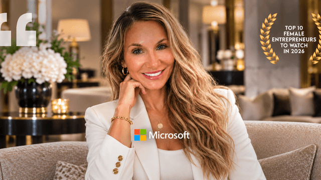 Smiling woman in a blazer sits in a stylish interior, showcasing entrepreneurial achievement