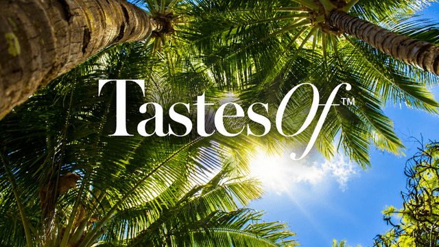 Sunlight filtering through palm trees with the text TastesOf above.