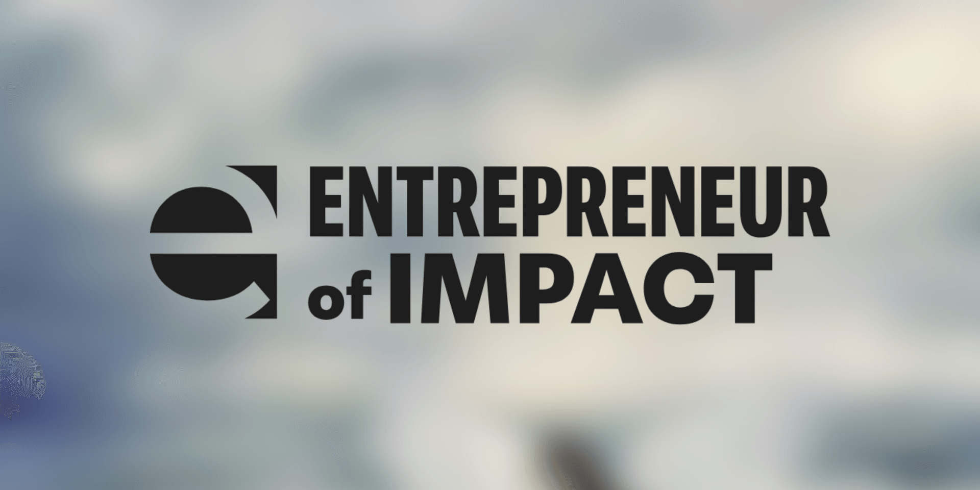 Logo for Entrepreneur of Impact with a blurred background