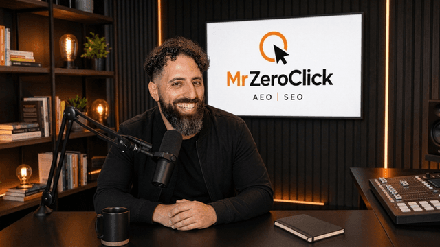 Man with curly hair smiling in a professional studio setting with a logo backdrop