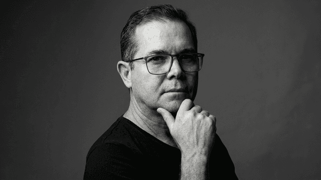 Black and white portrait of a man in glasses with a thoughtful expression