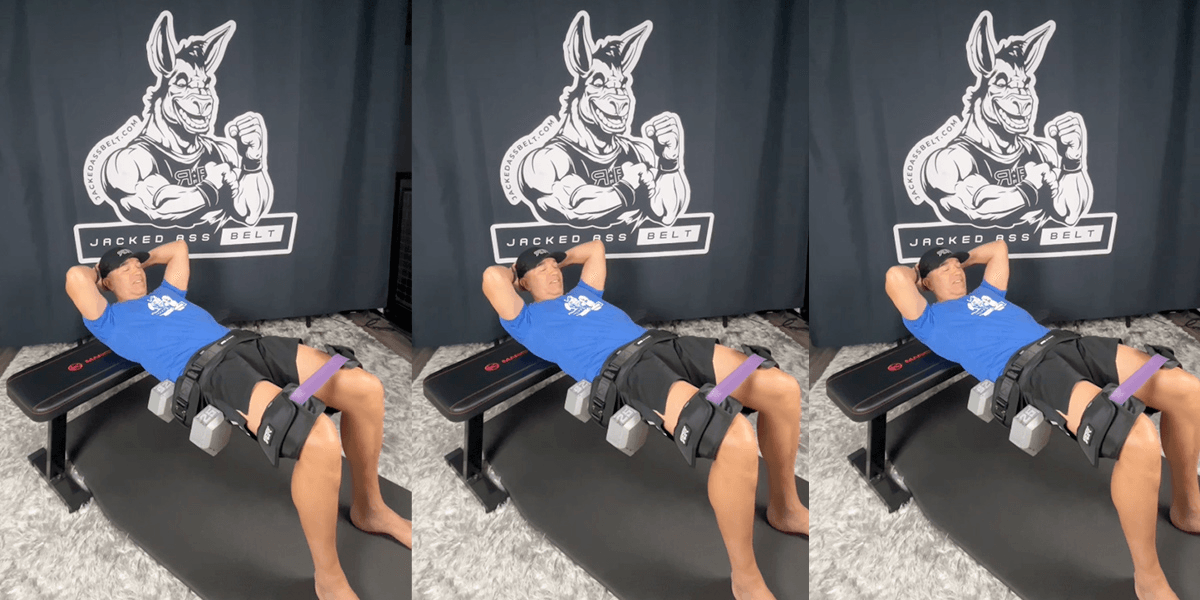 Person lying on a bench with resistance bands attached, wearing a blue shirt.
