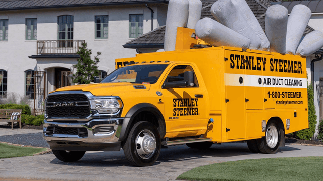 Yellow Stanley Steemer truck for air duct cleaning parked in a residential area