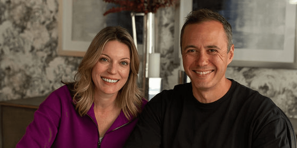 A smiling man and woman sitting together in a stylish indoor setting