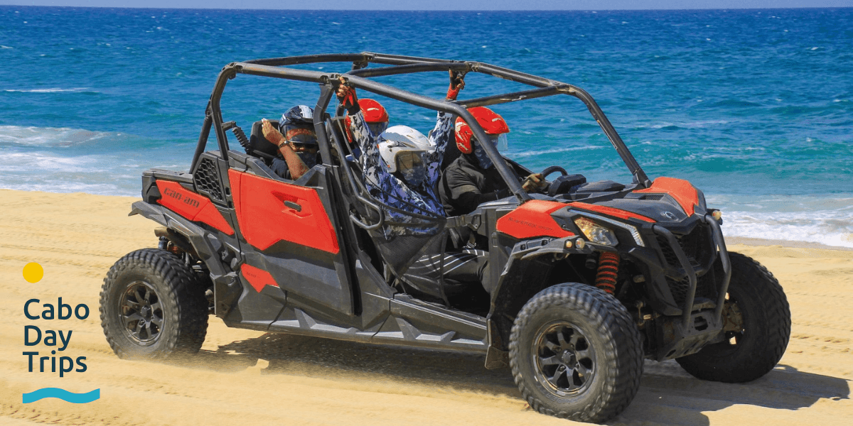 "Off-road adventure vehicle on a sandy beach, offering thrilling tours in Los Cabos with Cabo Day Trips logo."