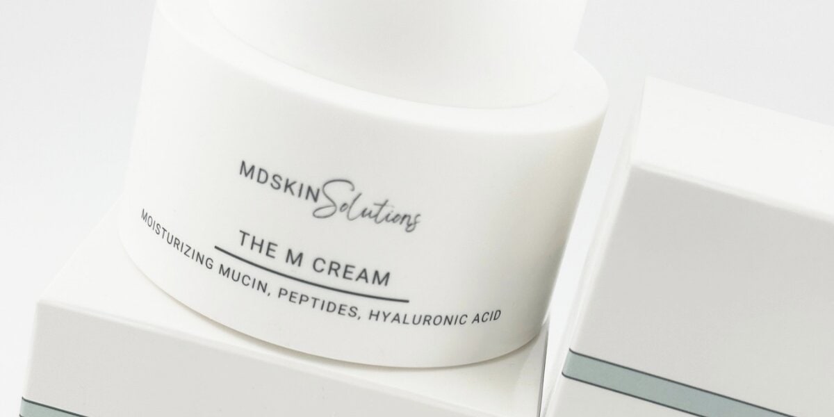 MD Skin Solutions The M Cream moisturizer highlighting peptides, hyaluronic acid, and moisturizing mucin formula.