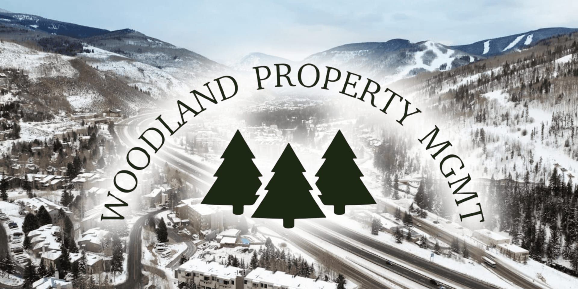 Woodland Property Mgmt logo over snowy mountain town and highway aerial view.