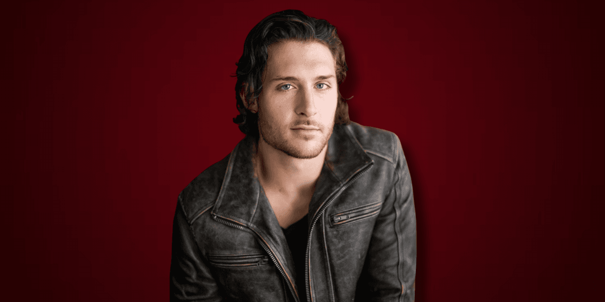 Nate Mayes wearing a dark leather jacket against a deep red background.