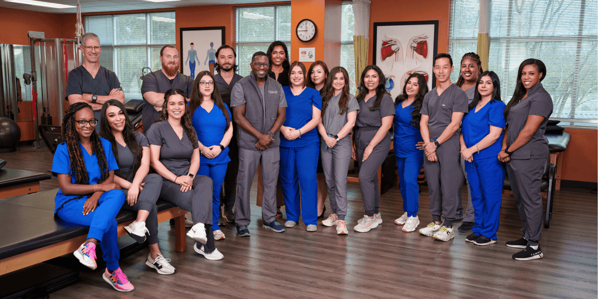 Group photo of Sterling Physical Therapy & Wellness team in clinic, showcasing diverse staff dedicated to patient recovery.