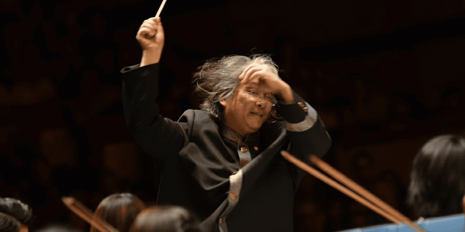 The image depicts a conductor passionately leading an orchestra, embodying the spirit of cultural fusion in opera performances.