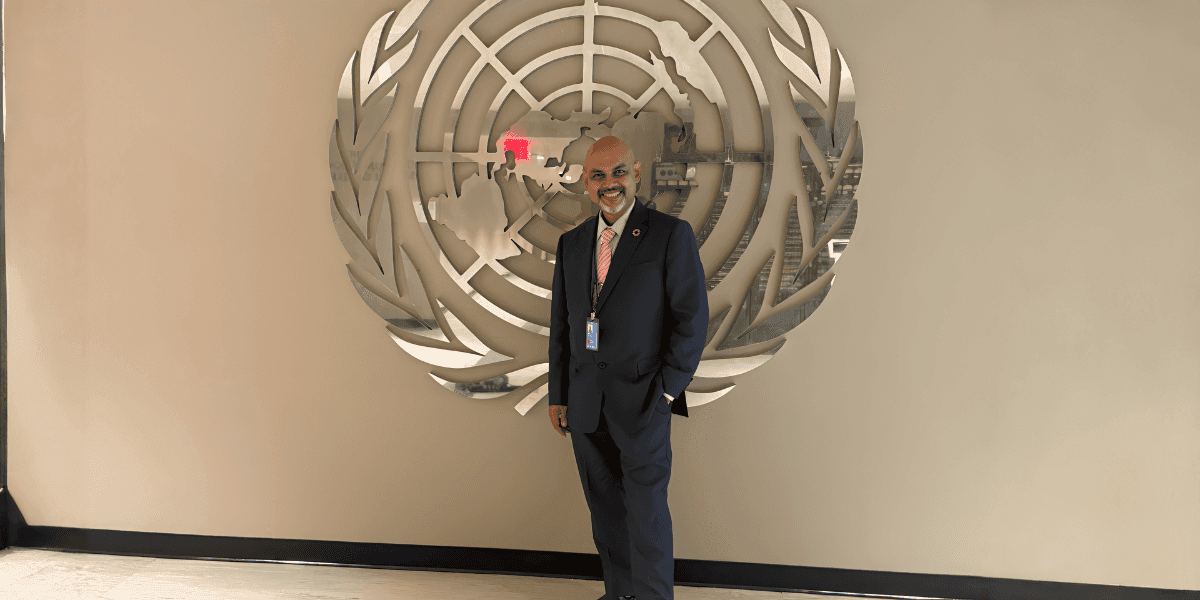 Suman Roy stands proudly in front of the United Nations emblem, symbolizing his global impact on food security.