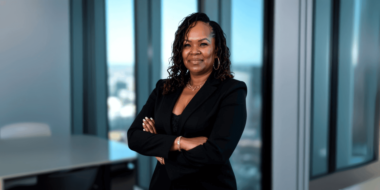 Natasha Norris stands confidently in a modern office, representing her movement, *Voices of Freedom*, empowering untold stories.