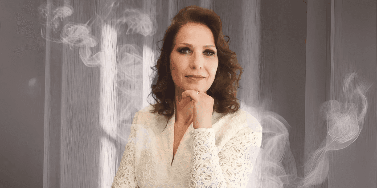 Elegant woman in lace white dress with smoke effect background, looking confident and thoughtful.