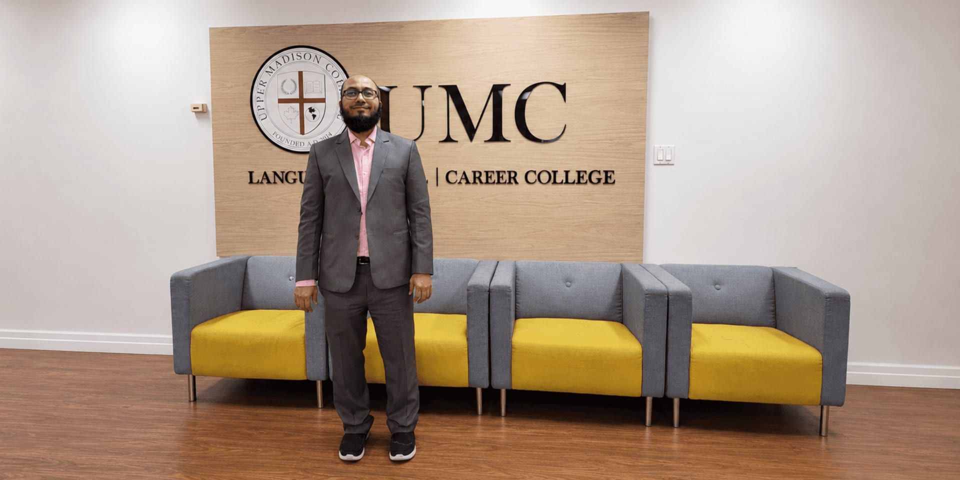 Taher Saifuddin, Principal of Simcoe High School, standing in the Upper Madison College lobby.