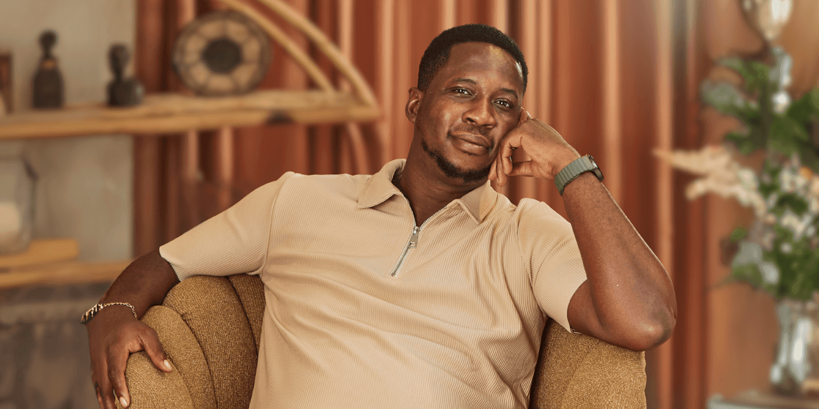 Gift Edah, founder of Rayvolution Media, is captured in a thoughtful moment, embodying creativity and social impact through media.
