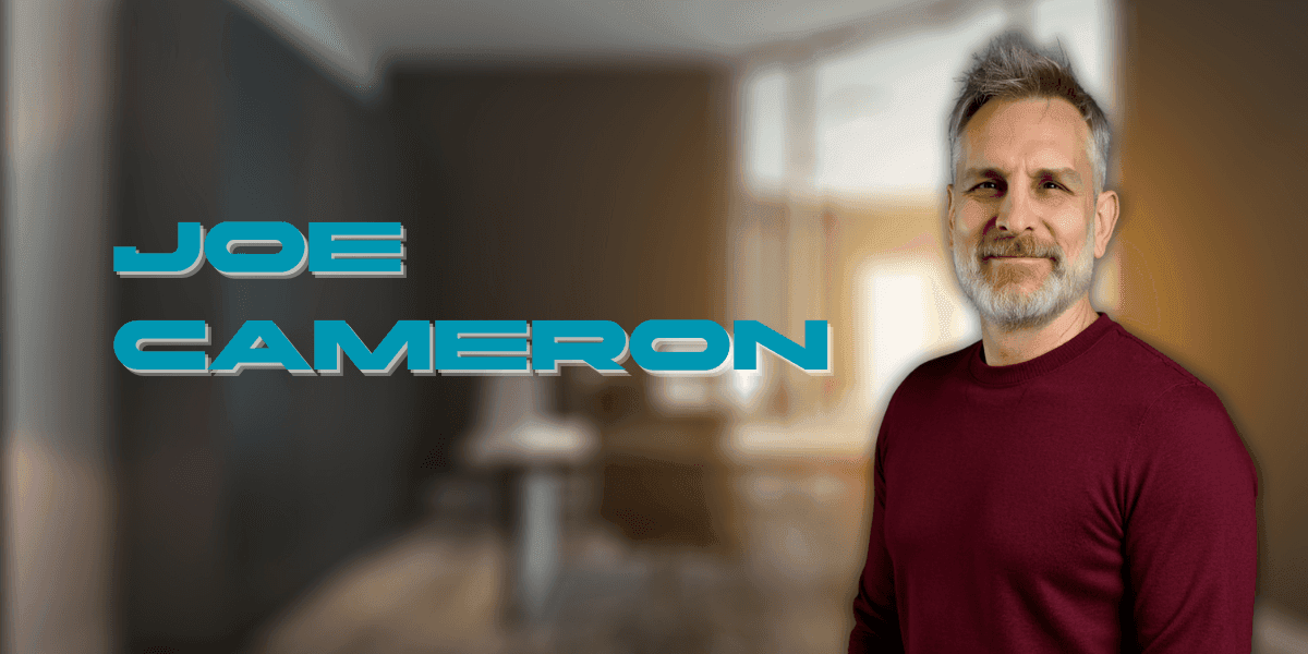 Professional headshot of Joe Cameron, a mature man with gray hair and beard, wearing a maroon sweater, smiling confidently in a modern office setting. His name 'Joe Cameron' appears in bold futuristic blue text on the left.