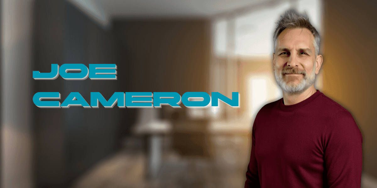 Professional headshot of Joe Cameron, a mature man with gray hair and beard, wearing a maroon sweater, smiling confidently in a modern office setting. His name 'Joe Cameron' appears in bold futuristic blue text on the left.