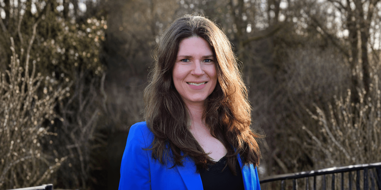 Ellen Duffy-Lueb, a women’s leadership strategist, smiling confidently in a blue blazer, advocating for burnout prevention and energy management.