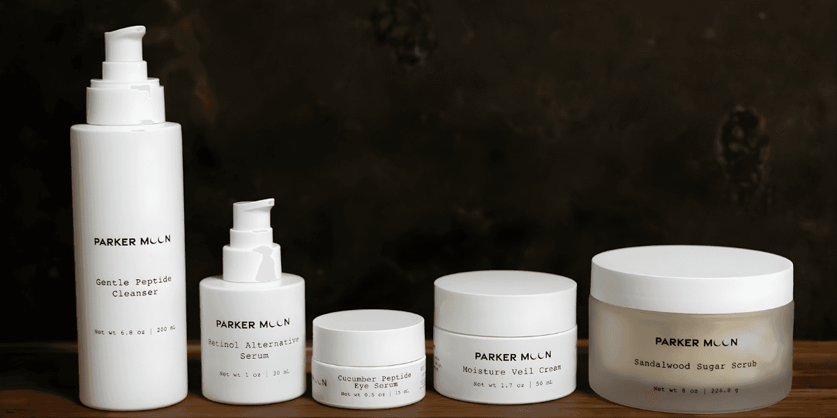 Luxury skincare products from Parker Moon, including cleanser, serums, moisturizer, and scrub, designed for sensitive skin