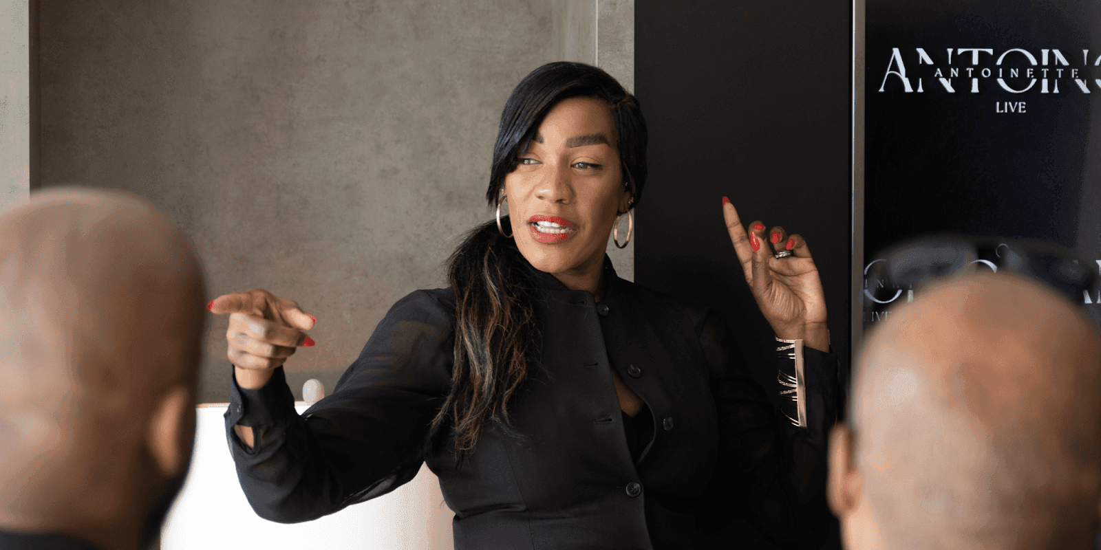 "Antoinette Antoine, executive reinvention coach, speaking passionately to a group, offering strategic guidance through leadership challenges and personal transformation."