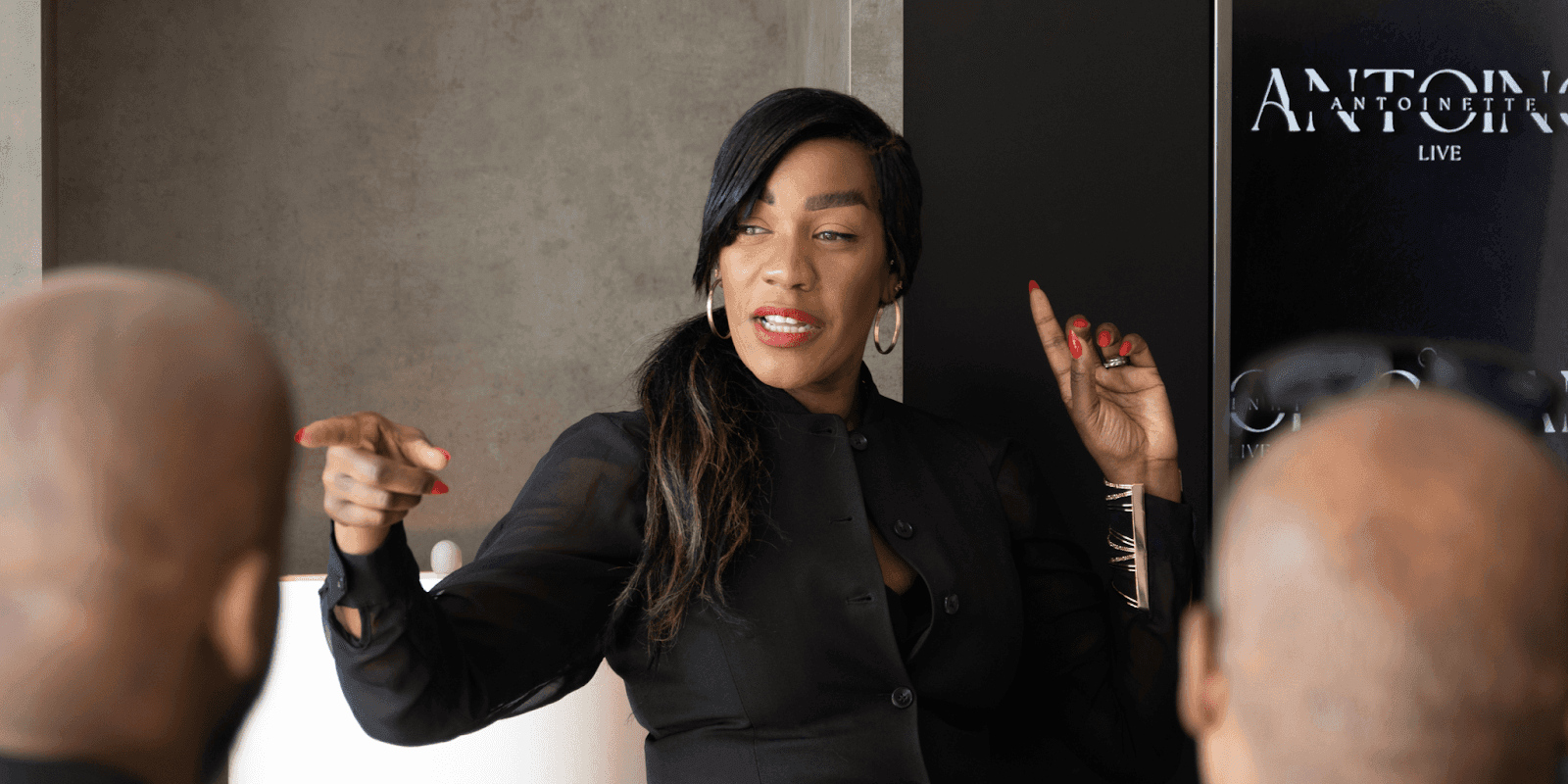 "Antoinette Antoine, executive reinvention coach, speaking passionately to a group, offering strategic guidance through leadership challenges and personal transformation."